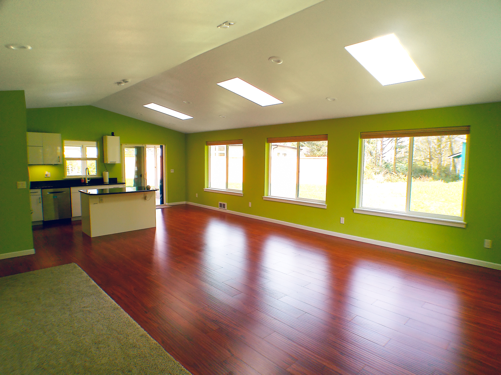 The open floor plan connects the living room to the kitchen and exits to the sunroom. The dining area, close to the kitchen island, allows for convenient dining with a view of the backyard.