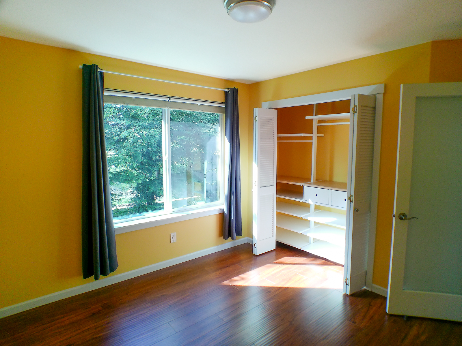 The third bedroom shares the same modern, bright color palette, large windows, and custom closets. All bedrooms feature smart thermostats and USB outlets for modern convenience.