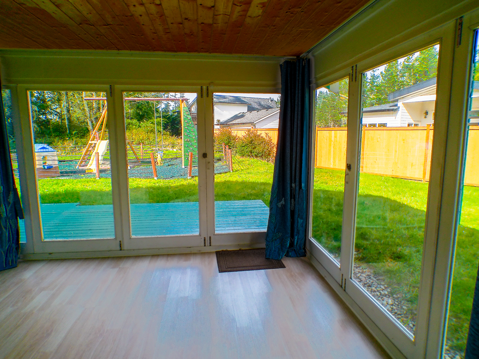 The sunroom opens to the backyard, filling the space with bright, sunny light — perfect for relaxing mornings or as a second living room. Views stretch to the playground, the second lot, and the detached studio. In the evenings, it transforms into an awesome video room with the addition of a projector and screen.