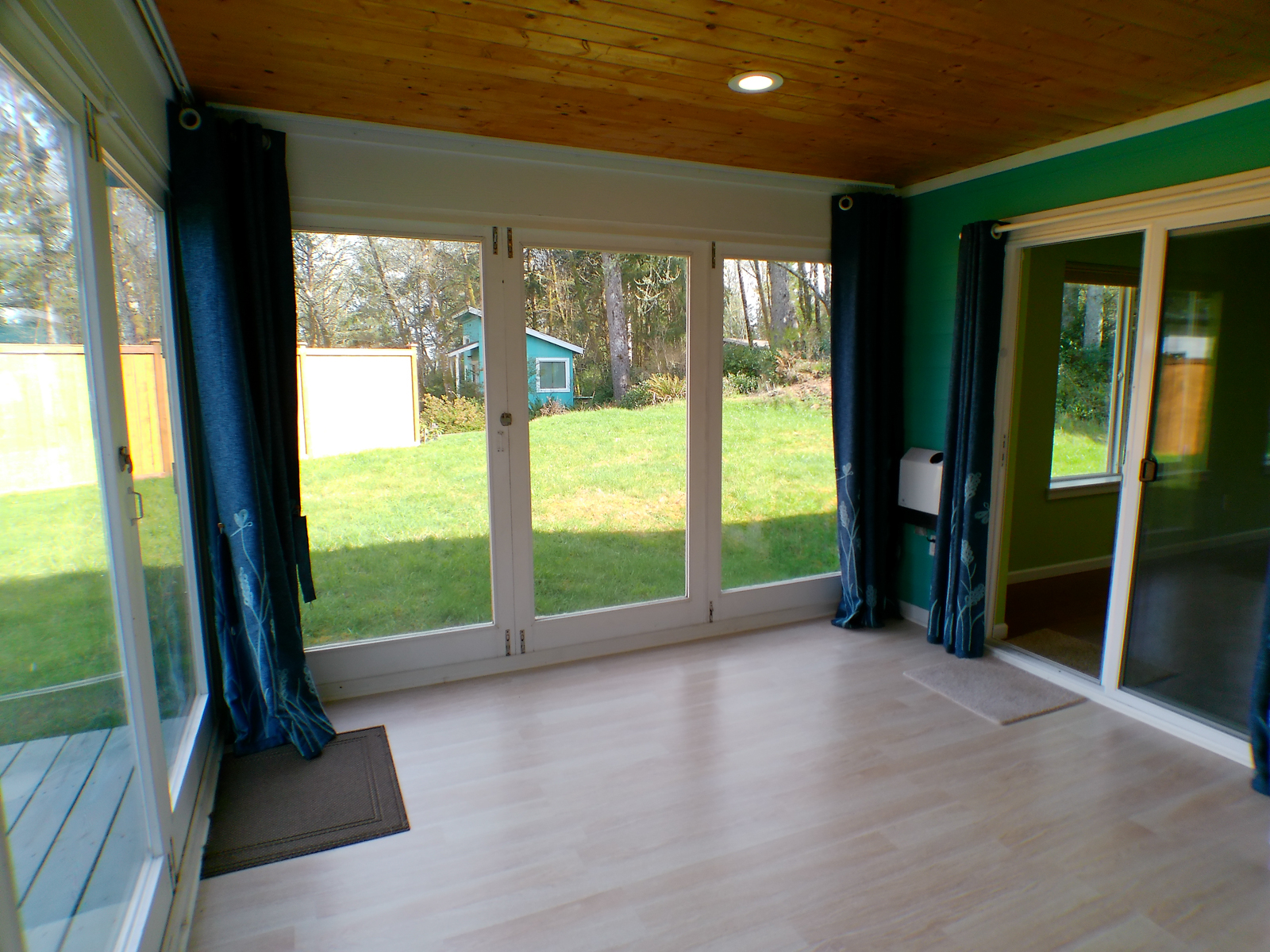 Accordion-style doors open completely, creating a seamless indoor-outdoor space perfect for breezy summer days. A smart programmable heater and light-blocking drapes keep the room comfortable year-round.